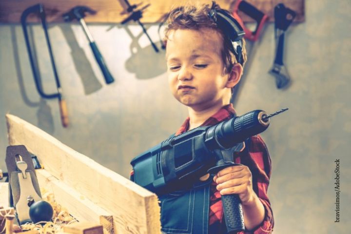 Frech schauender Junge mit Bohrmaschine in der Hand